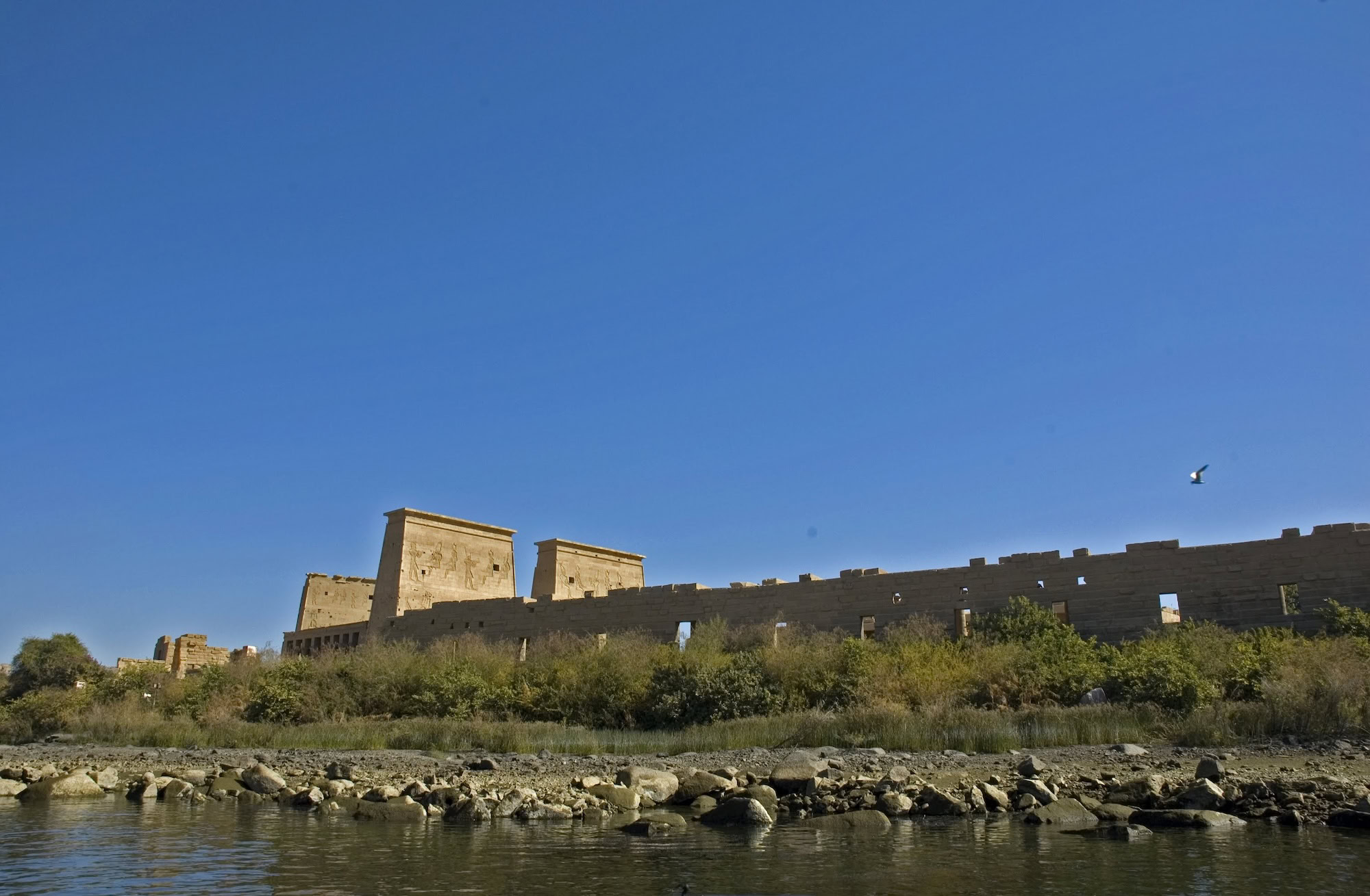 Temple of Philae viewed from the Nile River with ancient stone walls and fortress pylons
