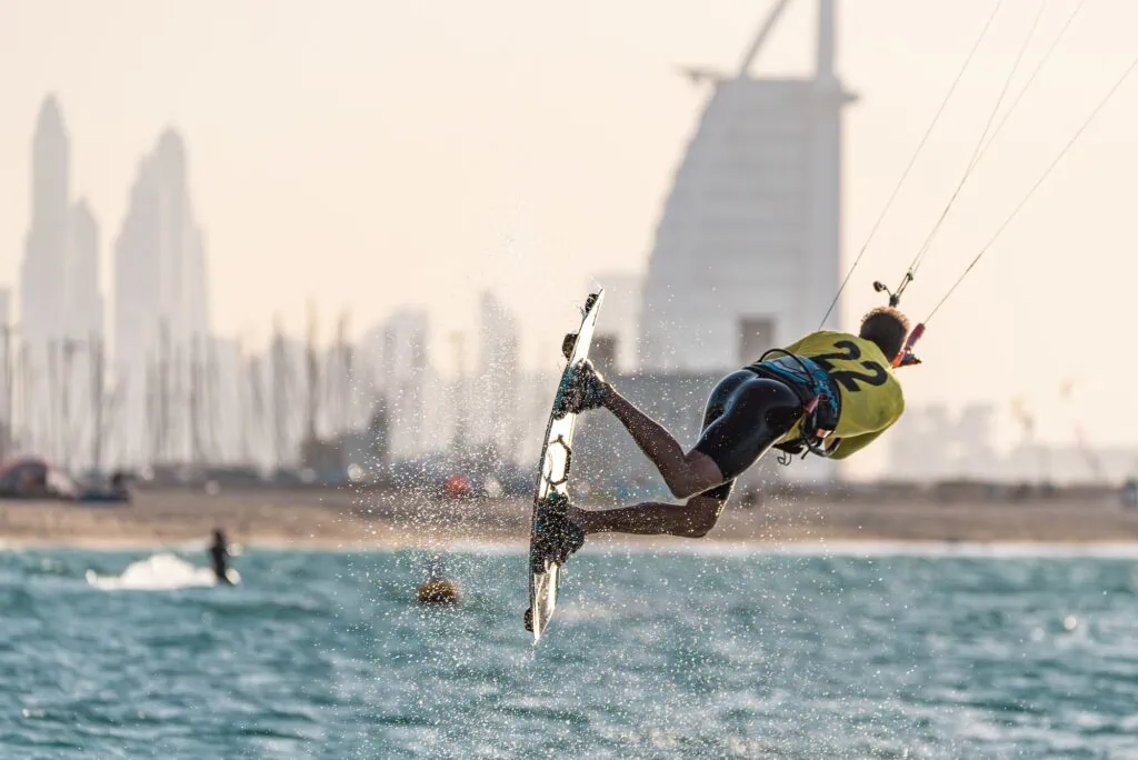 Kitesurfer performing freestyle jump at Kite Beach with Burj Al Arab Dubai