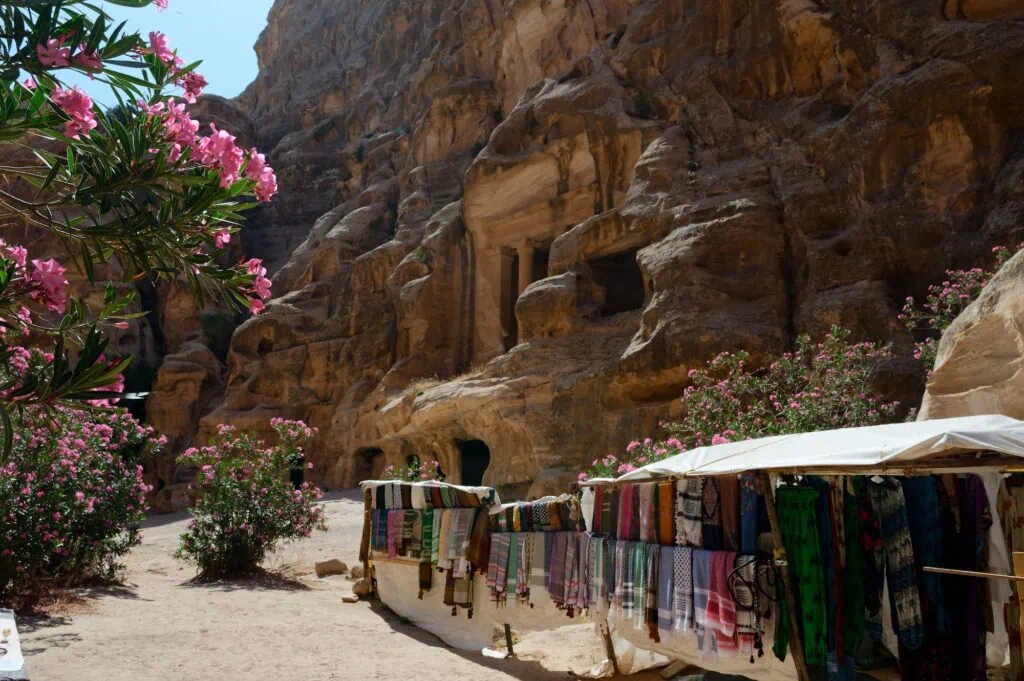 textlie shop in front of one of the structures in little petra colorful fabrics for sale in the archaeological site