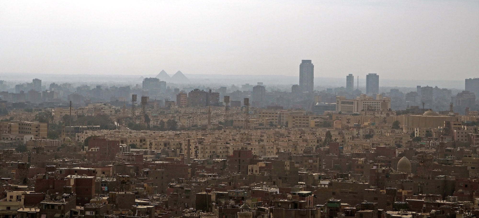 Aerial view of Cairo cityscape with pyramids and urban buildings