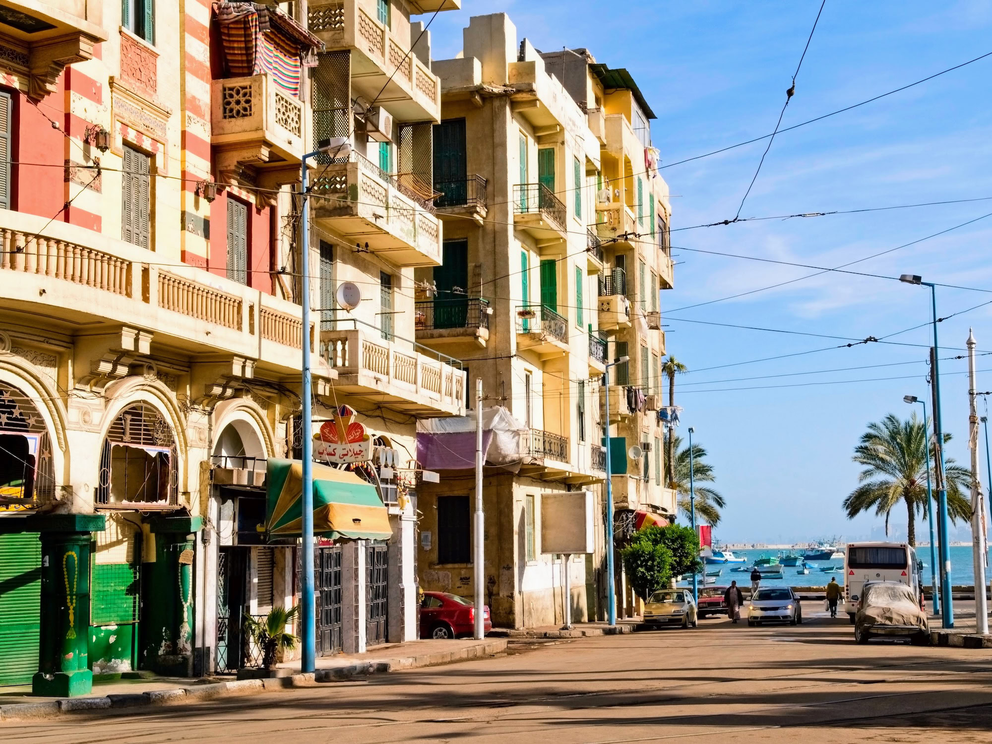 Rua costeira de Alexandria com palmeiras e vista para o mar Mediterrâneo
