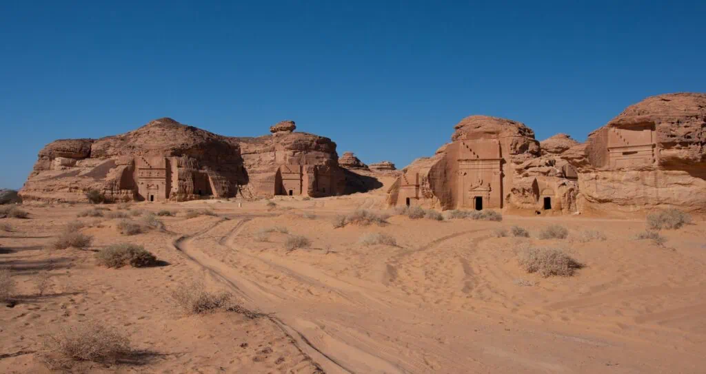 Rock-cut tombs amid desert landscape at Al-Hijr archaeological site