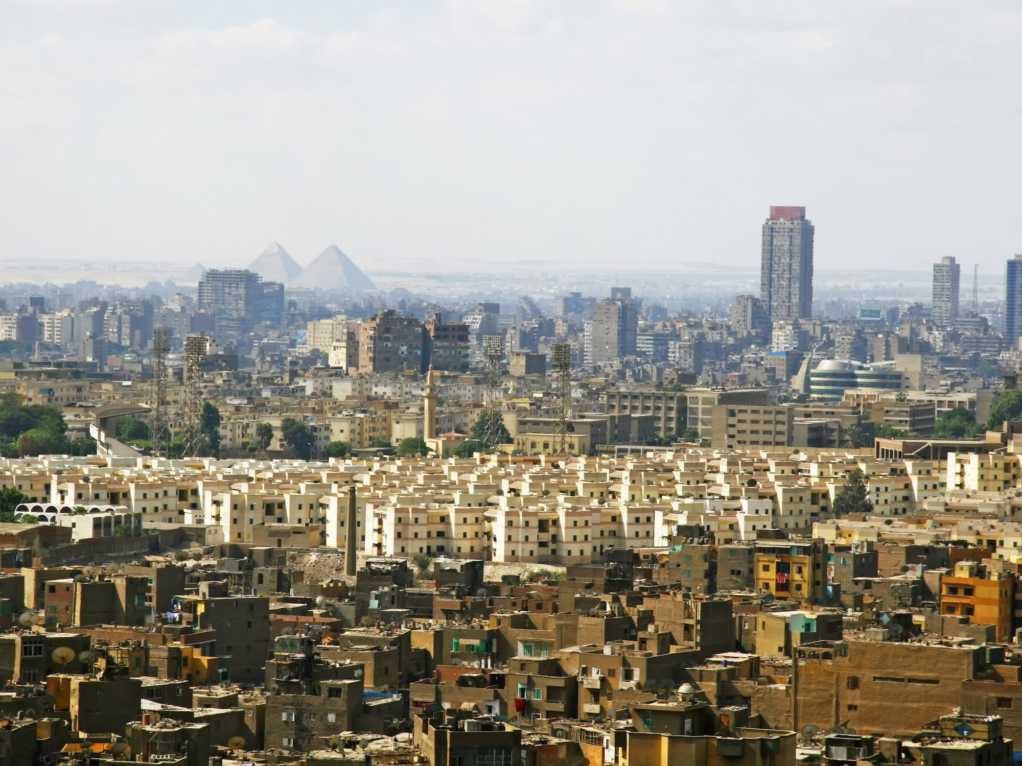 Pirâmides de Gizé vistas através do horizonte urbano moderno do Cairo