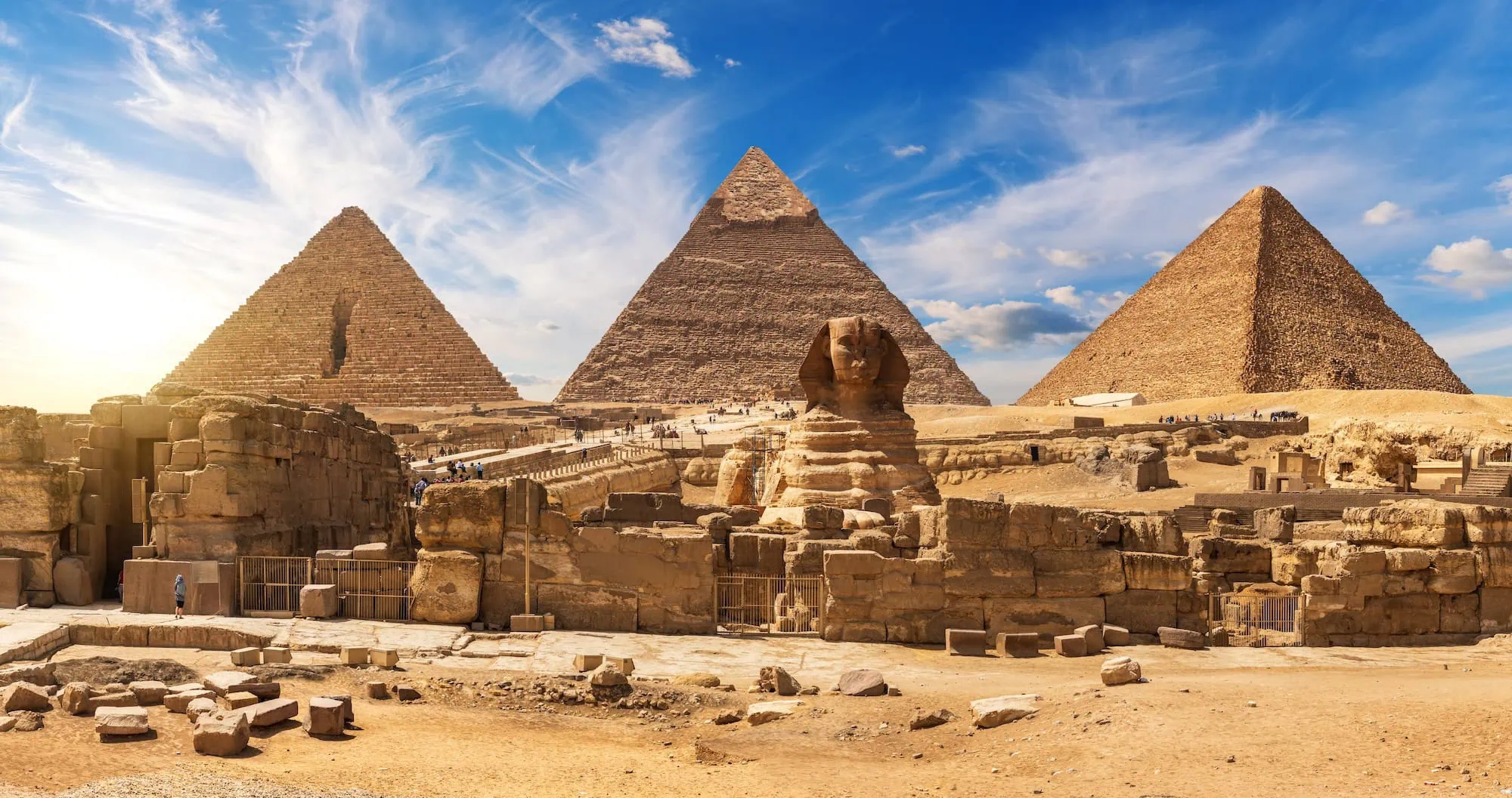 Tourists exploring the Great Pyramids of Giza and Sphinx on the desert plateau