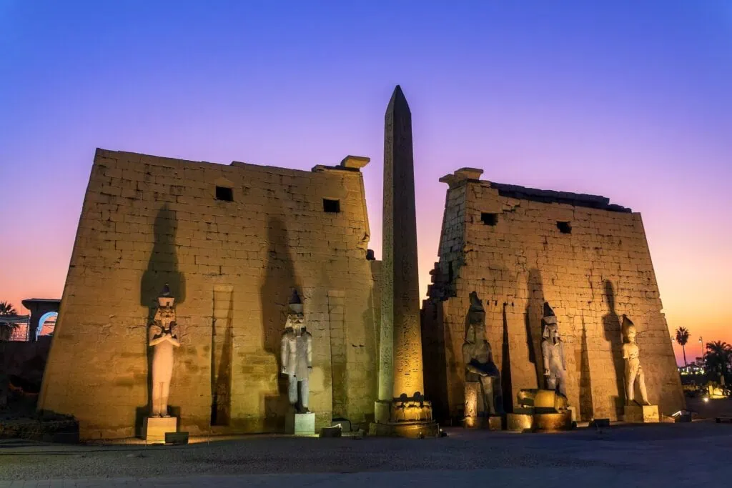 Illuminated facade of Luxor Temple with its ancient obelisk at night