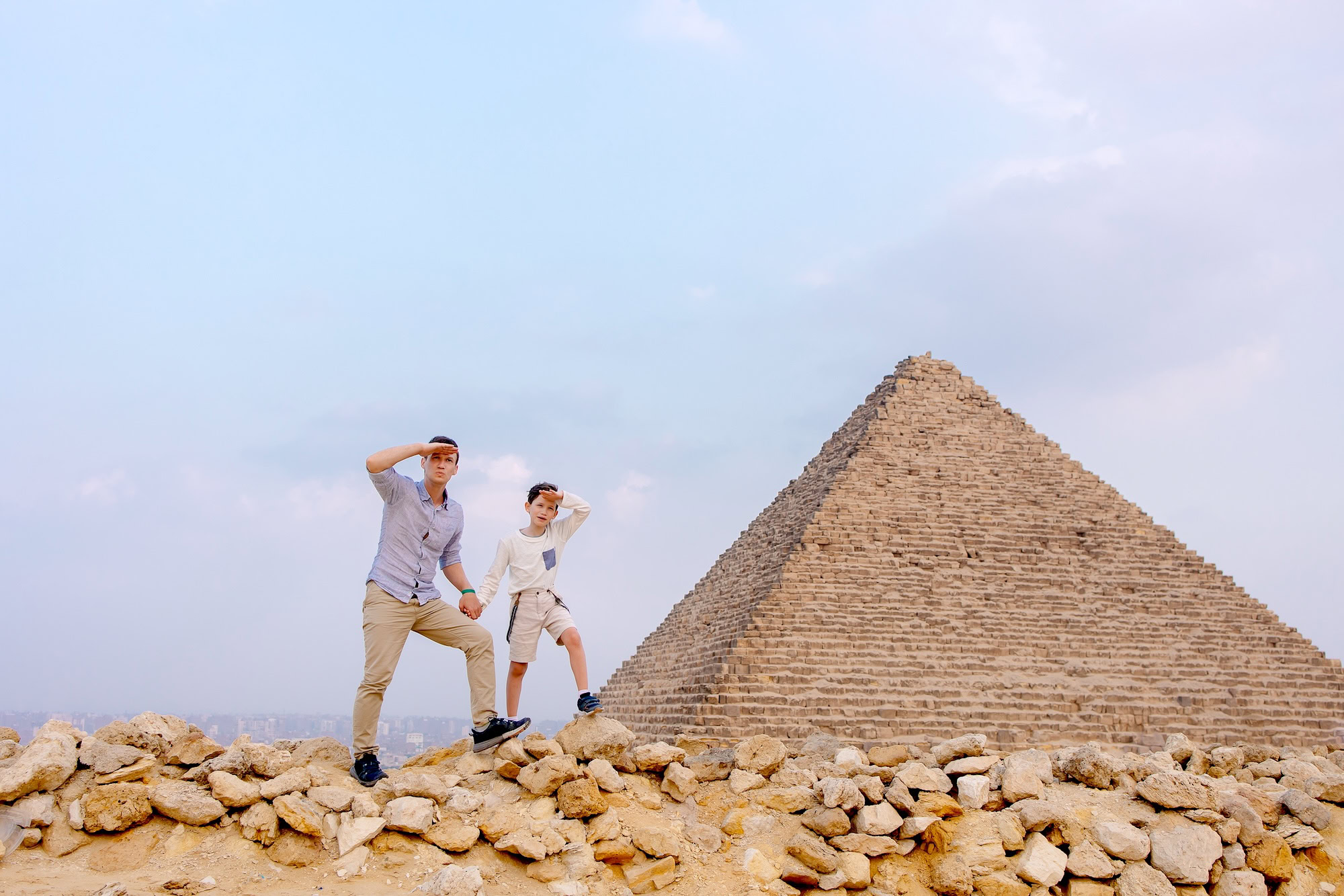 Father and child together in front of the pyramids in Cairo