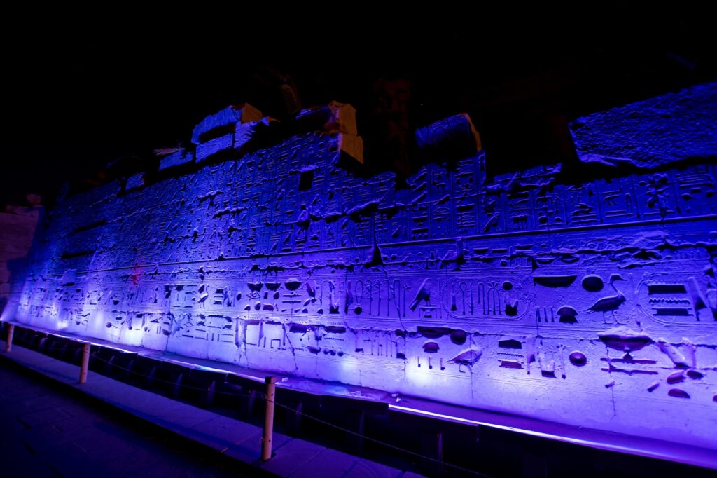 Hieroglyph-carved stone columns illuminated during the night Sound and Light show at Karnak Temple, Luxor