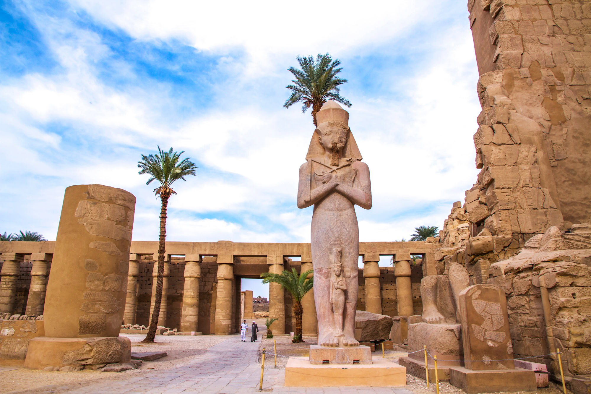 Ancient pharaoh statue and columns at Karnak Temple Complex in Luxor