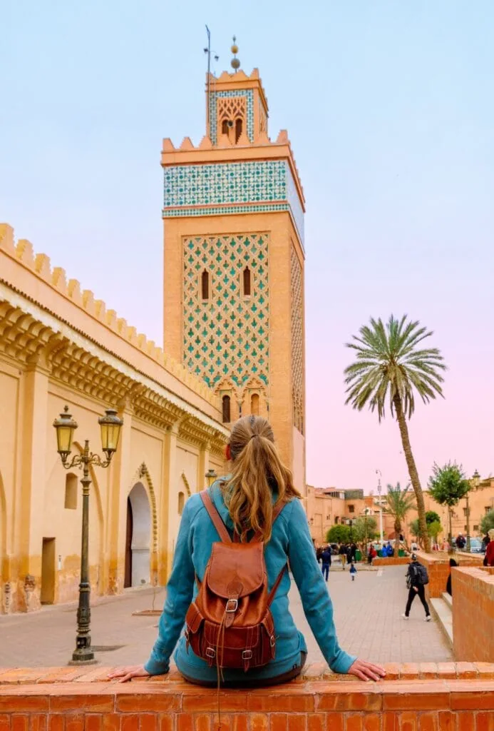 Woman facing the Koutoubia Mosque minaret in Marrakech