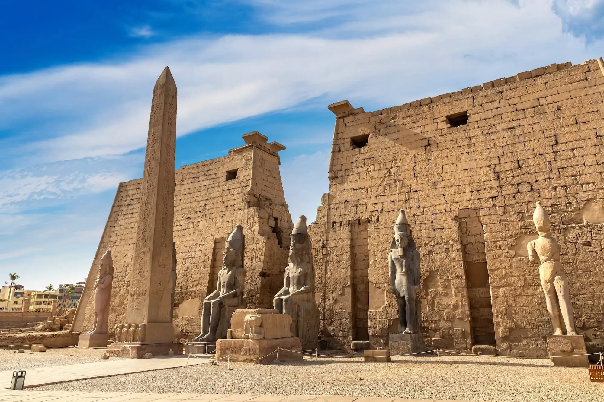 Luxor Temple under clear blue skies on a sunny day showing ancient Egyptian architecture