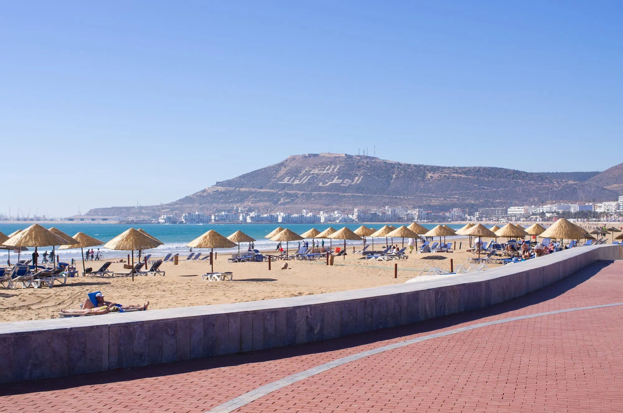 Agadir's main beach with golden sand, traditional umbrellas, and turquoise waters