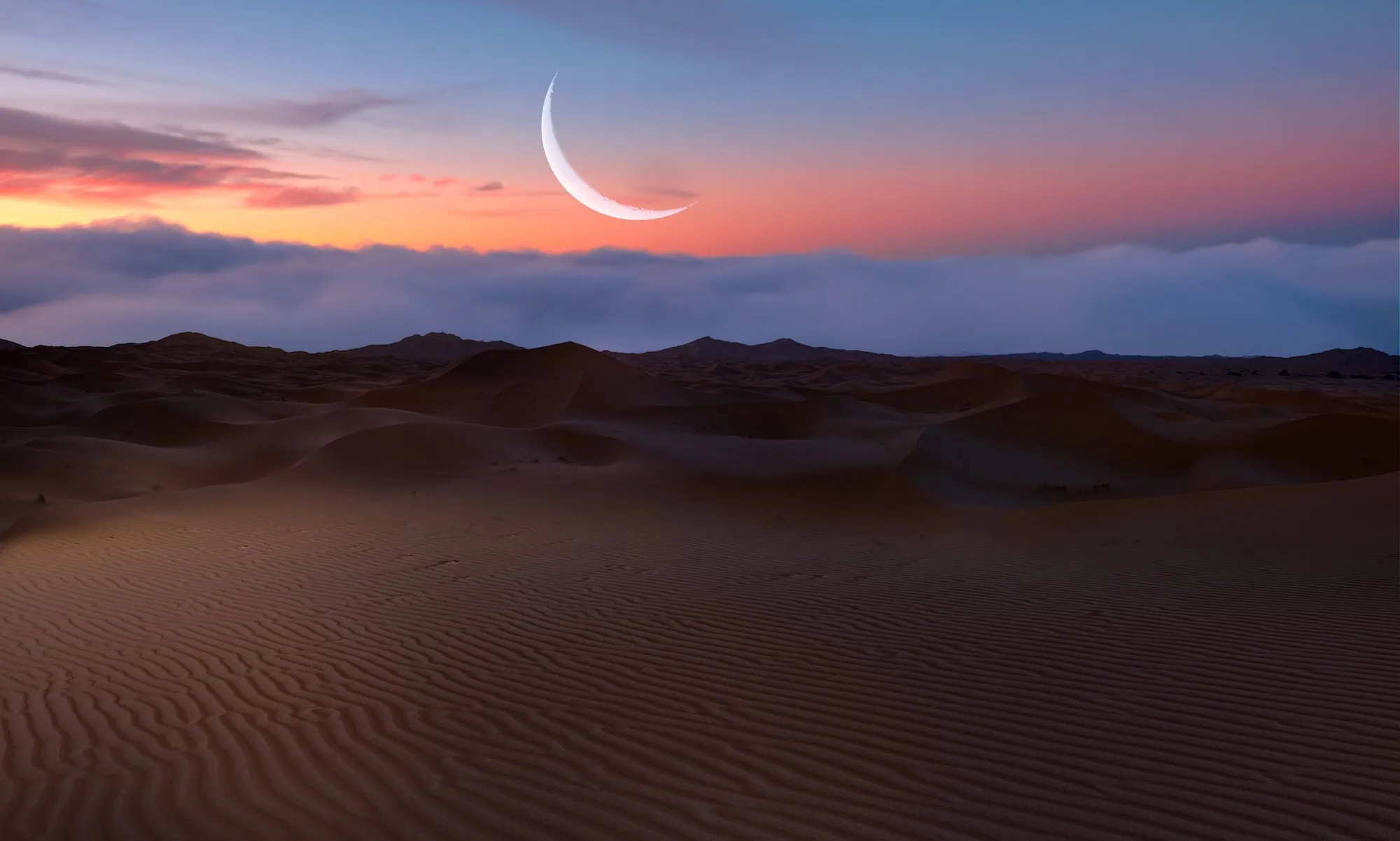 Spectacular Sahara Desert sunset with rolling sand dunes and crescent moon