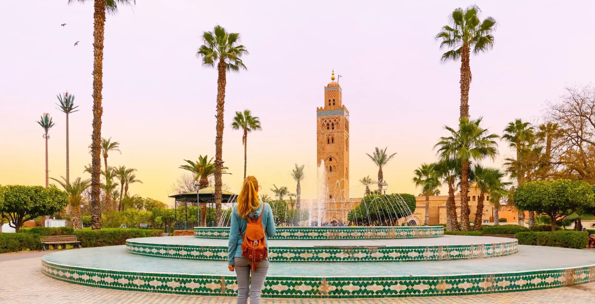 Woman looking at Koutoubia mosque minaret Tourism in Marrakech 1905x976 crop 54 68