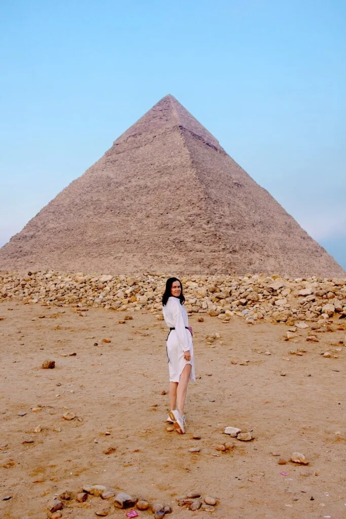 Woman standing in front of the pyramids on the desert plateau during a tourist visit, Giza