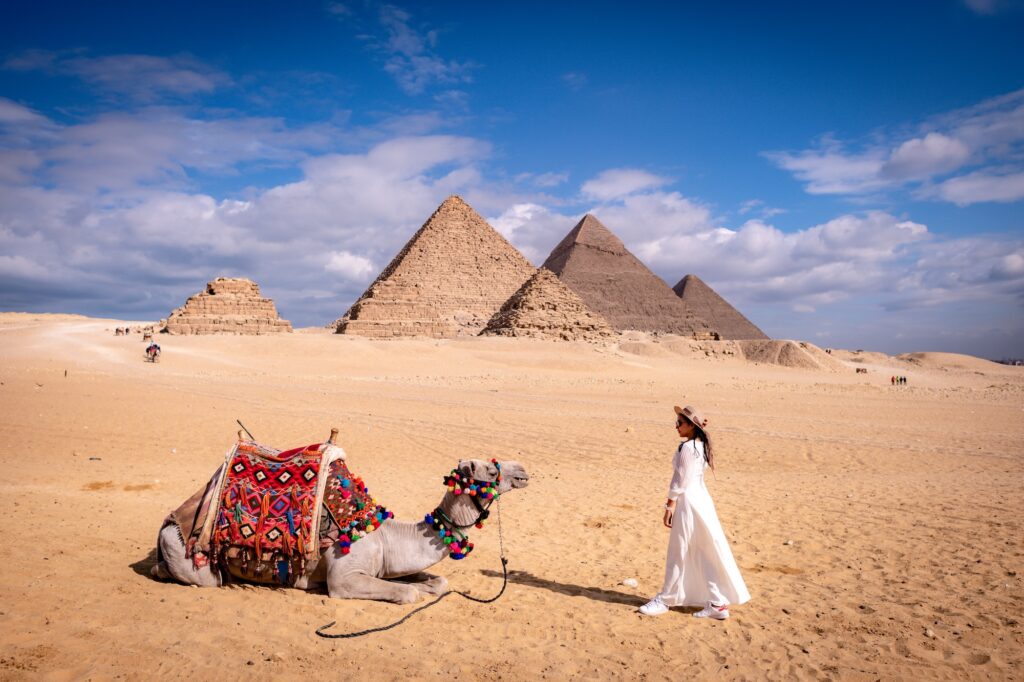 Woman wearing a white cooling cloth in the desert at the Great Pyramids of Giza