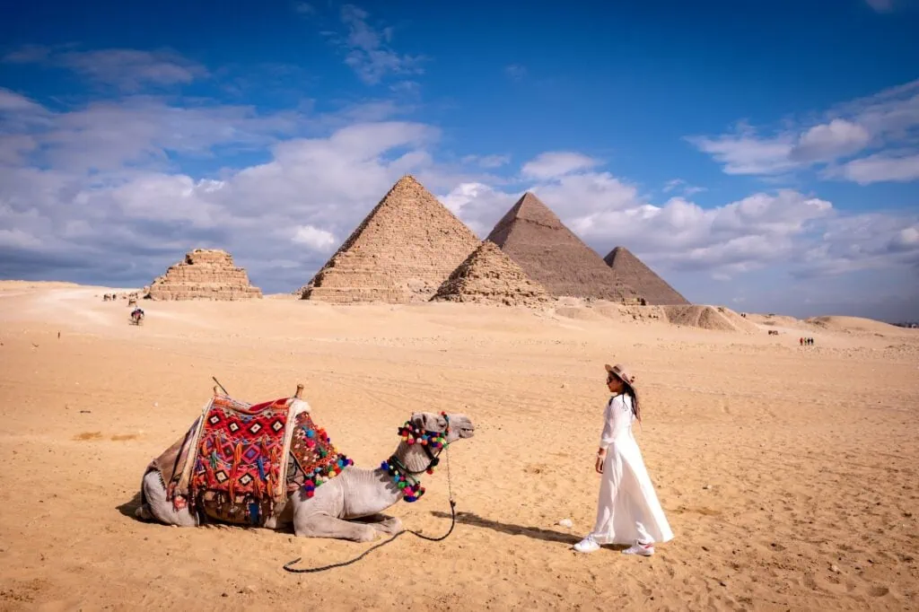 Woman wearing a white cooling cloth in the desert at the Great Pyramids of Giza