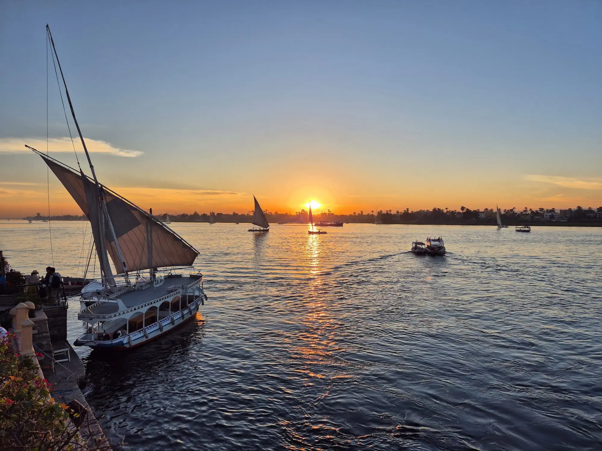 Traditional felucca sailboat on the Nile River at sunset in Egypt