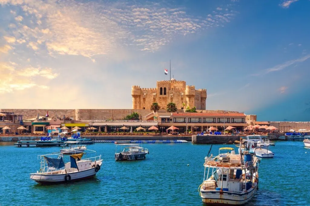 Small boats moored in the harbor waters near the Citadel of Qaitbay, Alexandria