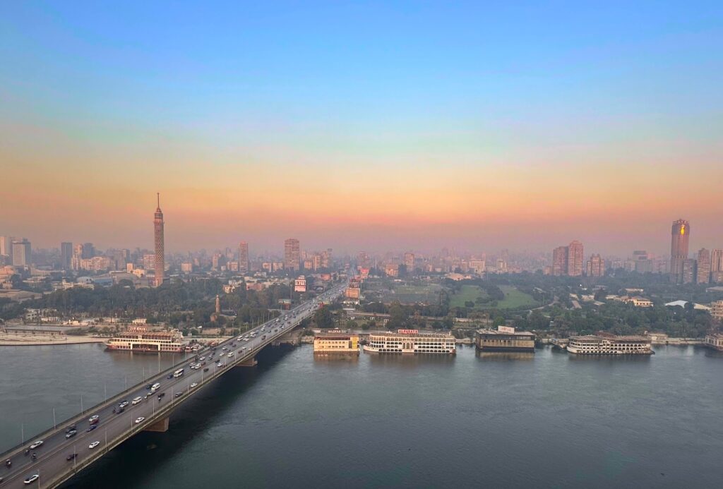 The city skyline as the sun sets over the flowing water, Nile River, Cairo