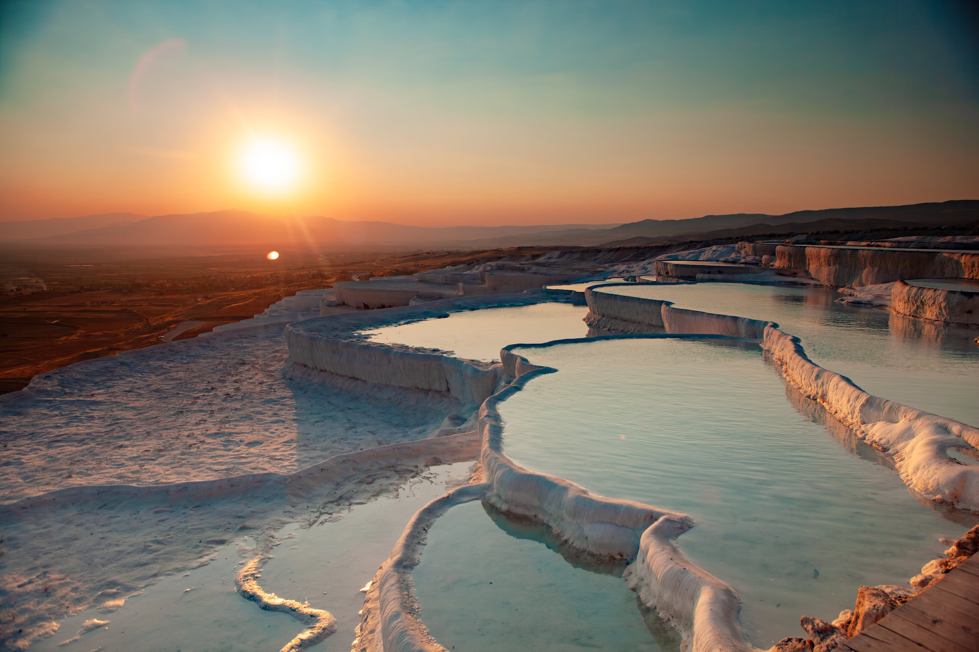 Captivating sunset over Pamukkales natural travertine terraces filled with turquoise thermal water