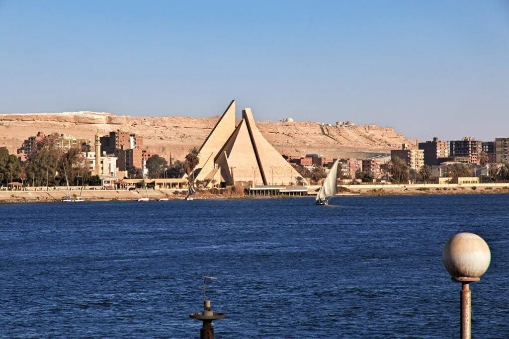Urban skyline and buildings along the Nile River with desert landscape in the background, El Minya