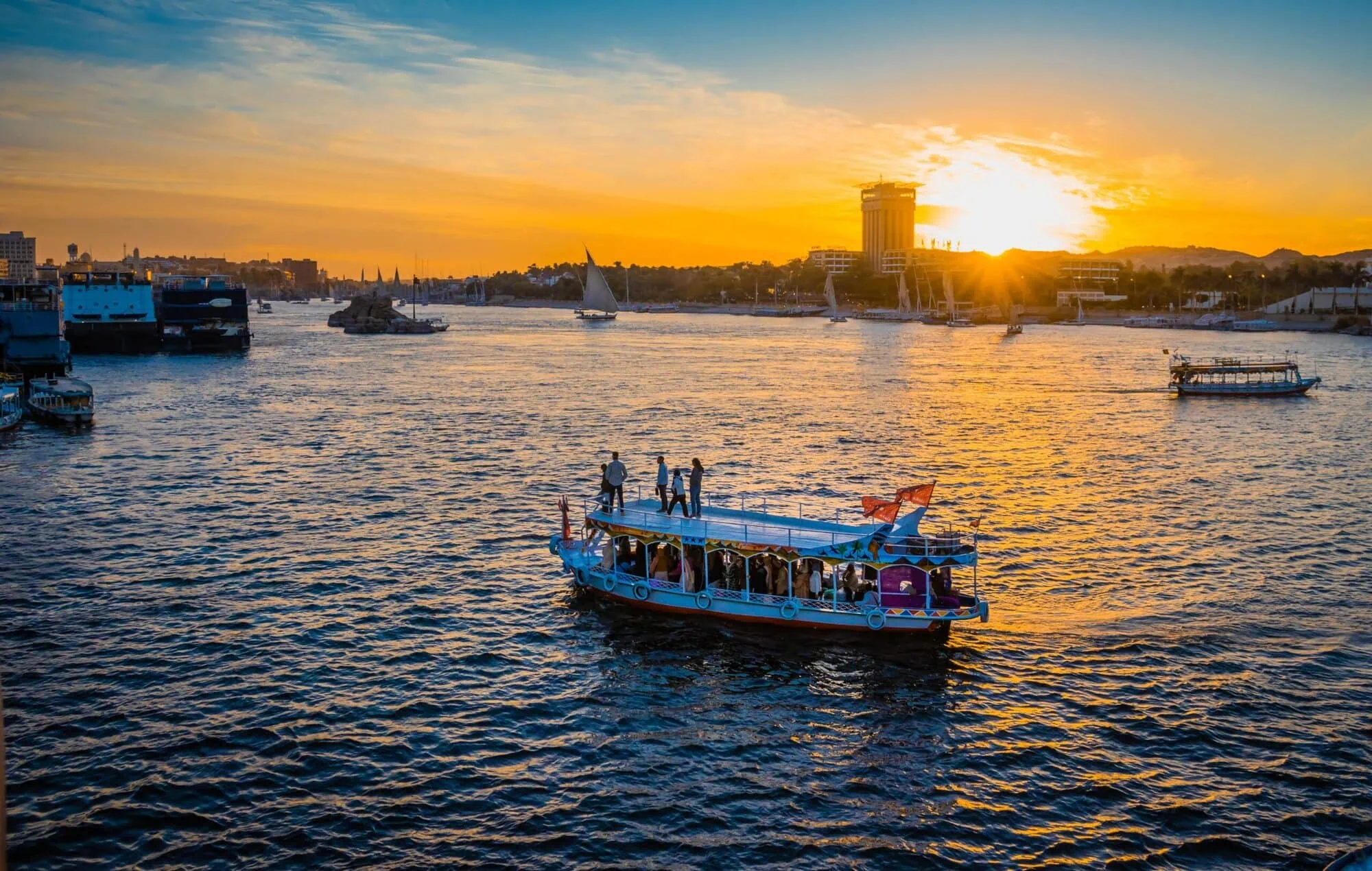 Barcos navegando por el río Nilo al atardecer con horizonte urbano