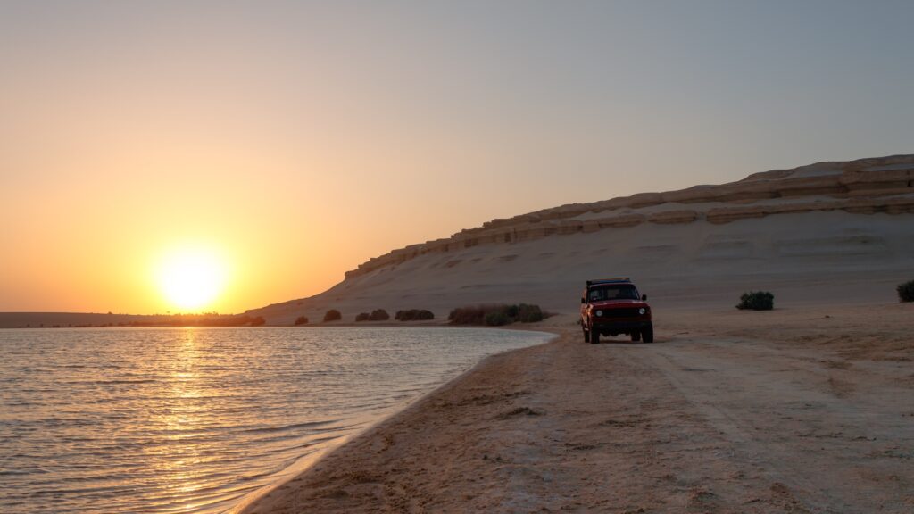 Magic Lake showing calm turquoise waters bordered by desert hills and sandy formations, Fayoum