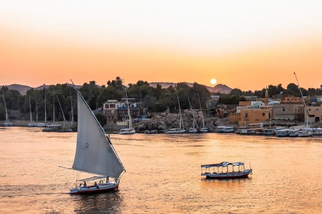 Felucca boat sailing on the Nile River at sunset, Aswan