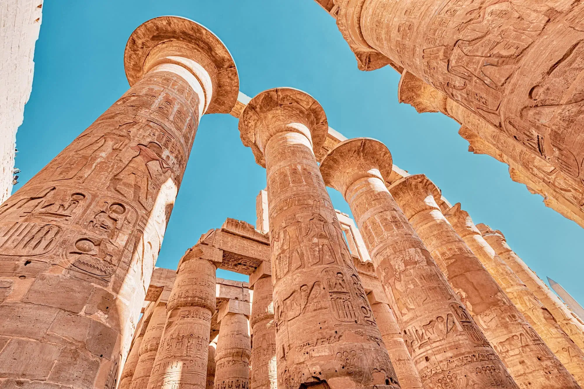 Massive ancient columns with hieroglyphic carvings at Karnak Temple's Great Hypostyle Hall