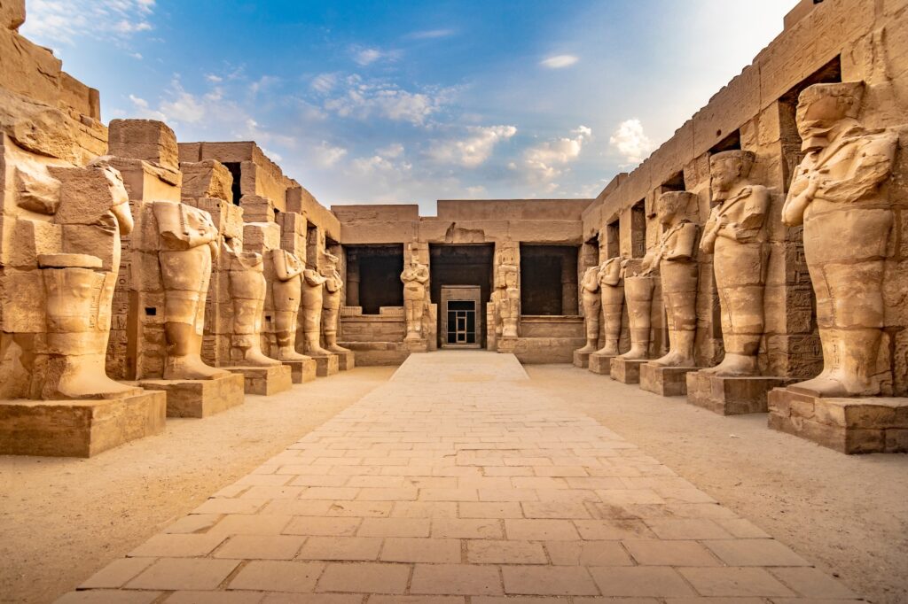 KARNAK TEMPLE Large pharaoh sculptures inside beautiful Egyptian landmark with hieroglyphics ancient symbols