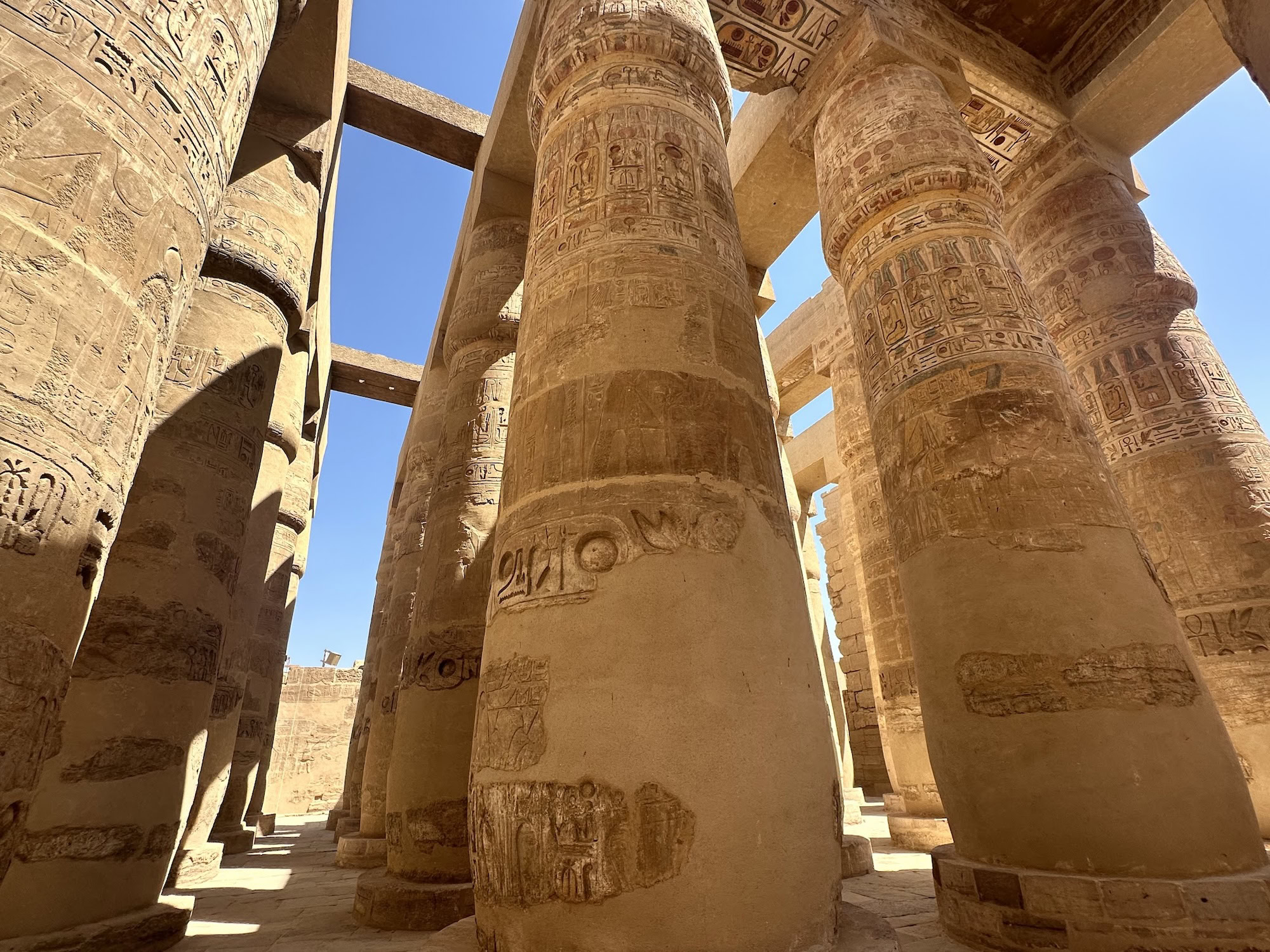Massive stone columns with hieroglyphs in Karnak Temple's great hypostyle hall