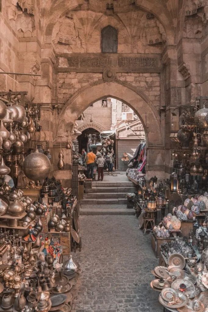 Vendors selling traditional brass pots and metal crafts at Khan el-Khalili Bazaar in Cairo