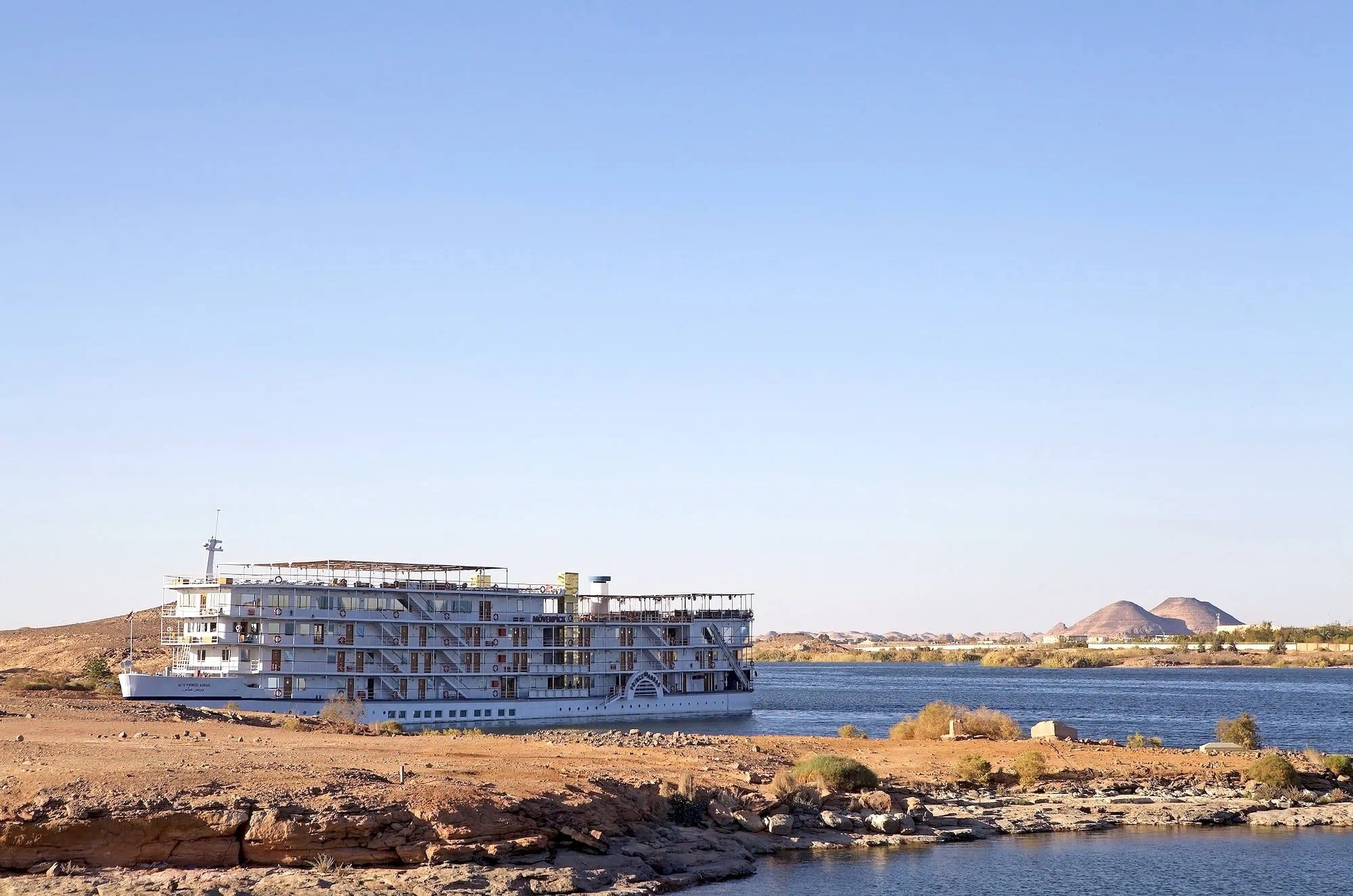 A Nile River cruise ship docked along the riverbank