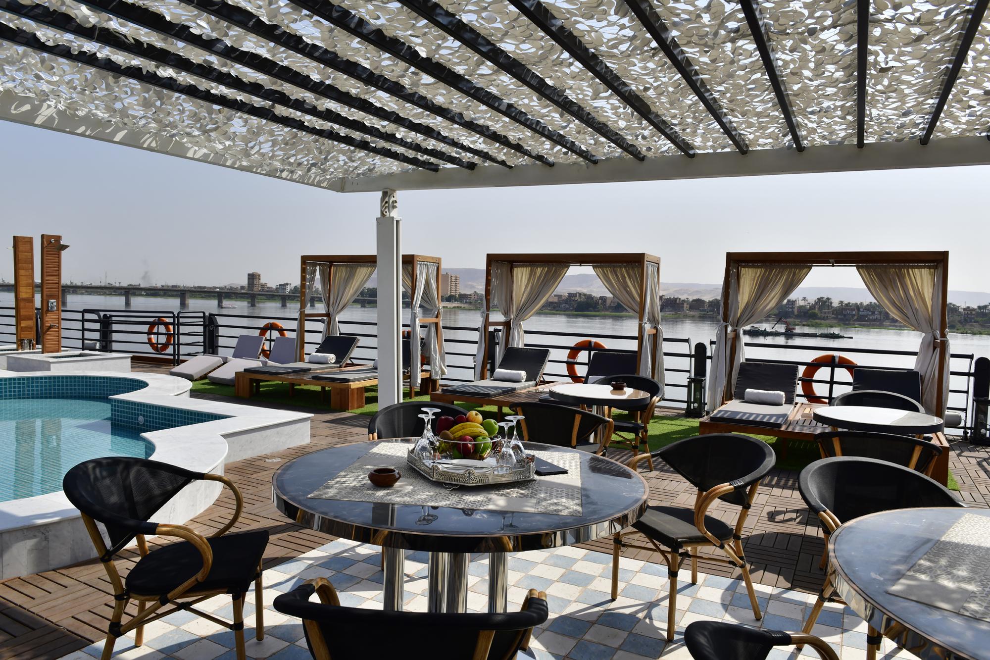 Deck solar no MS Mayfair com espreguiçadeiras e guarda-sóis