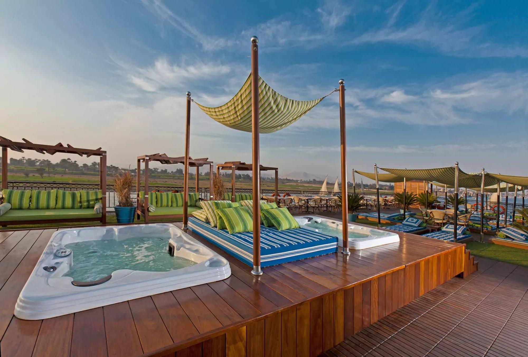 Luxury Nile River cruise ship deck with hot tub, daybed, and canopy at sunset