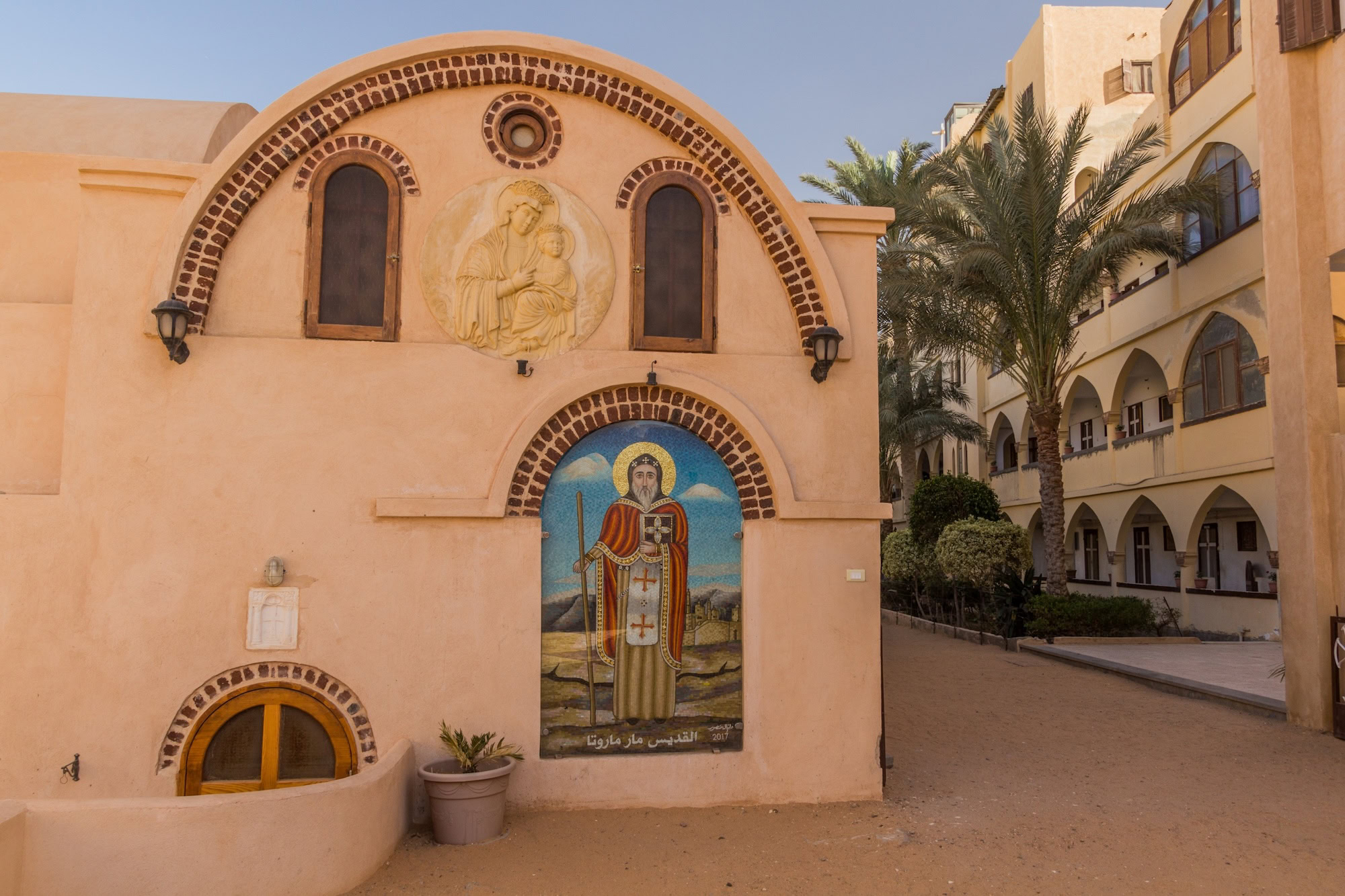 Coptic Orthodox monastery with arched facade and religious murals