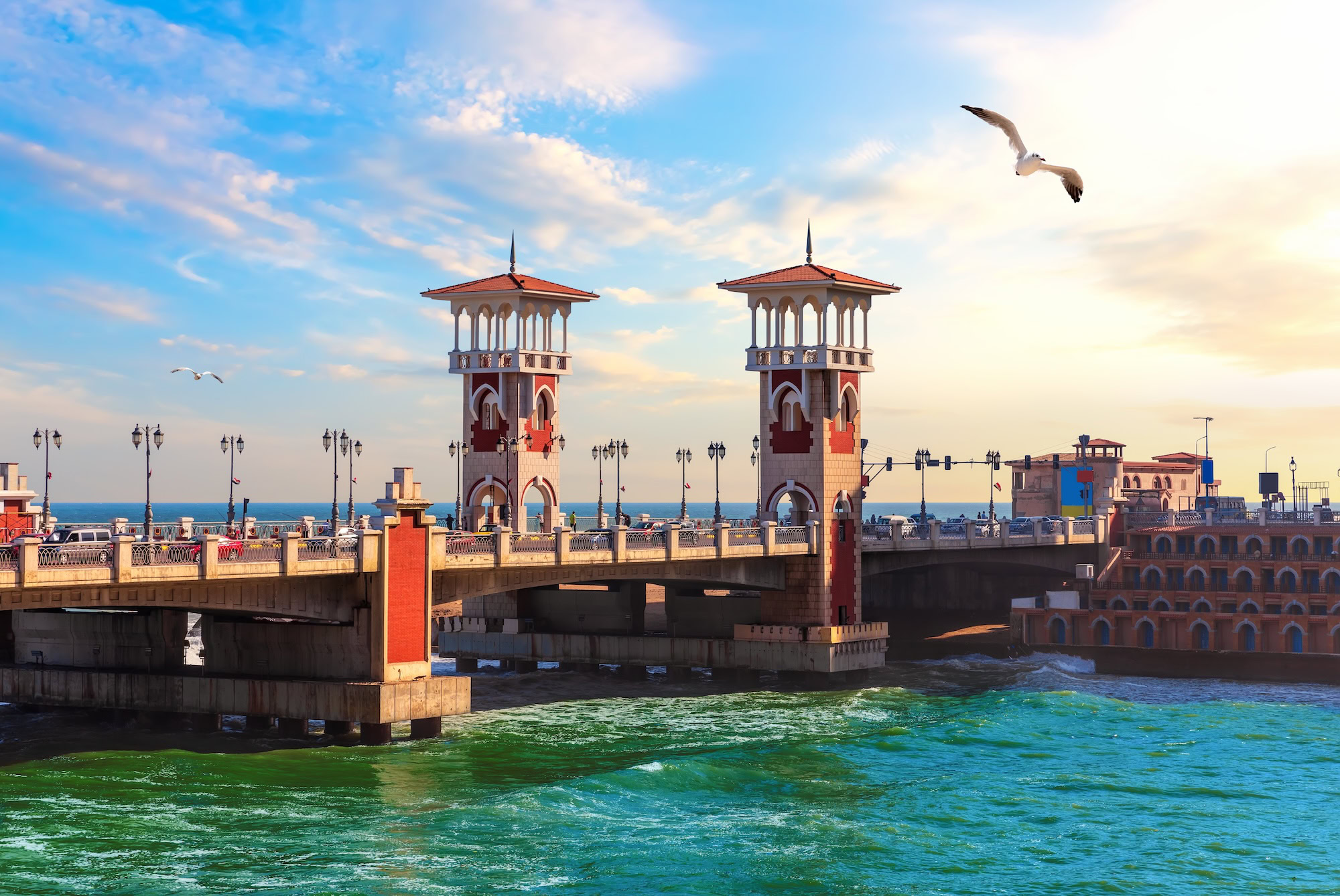 Stanley Bridge in Alexandria, Egypt with Islamic-style towers spanning turquoise waters at golden hour