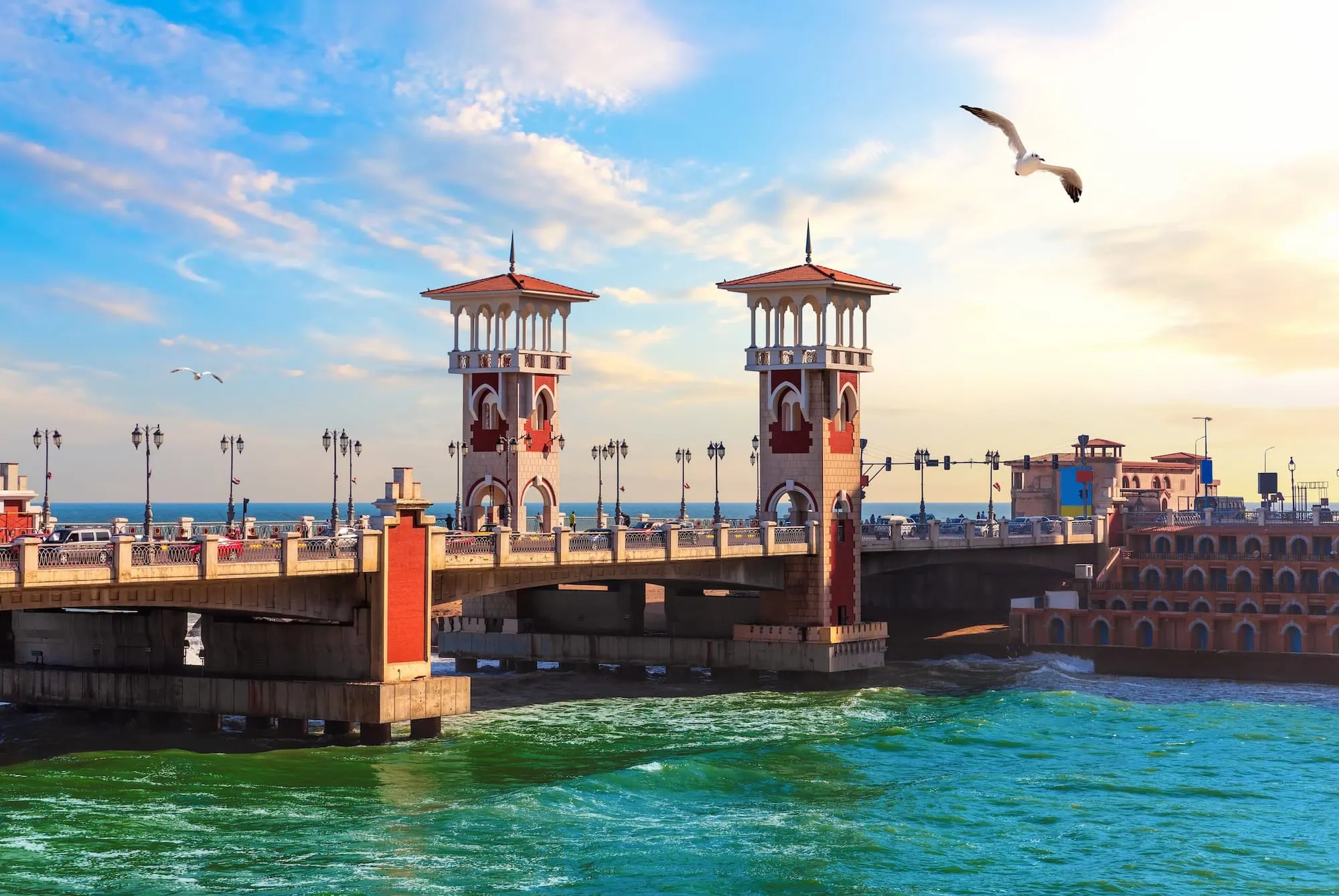 Stanley Bridge in Alexandria, Egypt with Islamic-style towers spanning turquoise waters at golden hour