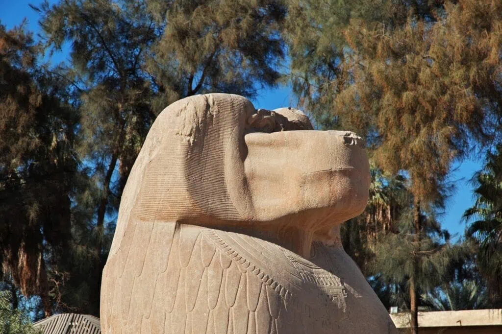 Stone statue of a baboon with carved details displayed outdoors in Minya, Minya