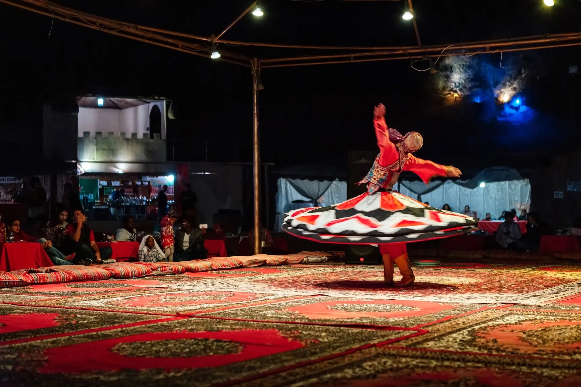 Traditional whirling dervish performer in colorful costume entertaining an audience
