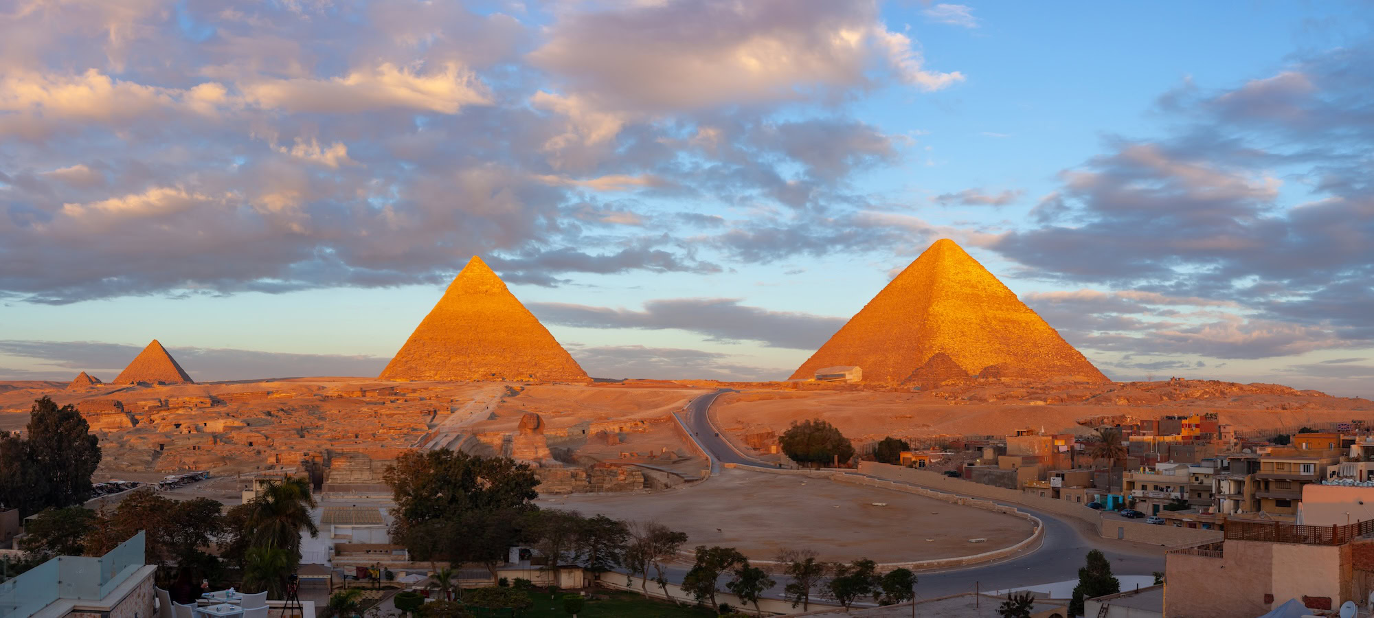 Sunrise view of the pyramids of Giza with golden morning light and clear sky