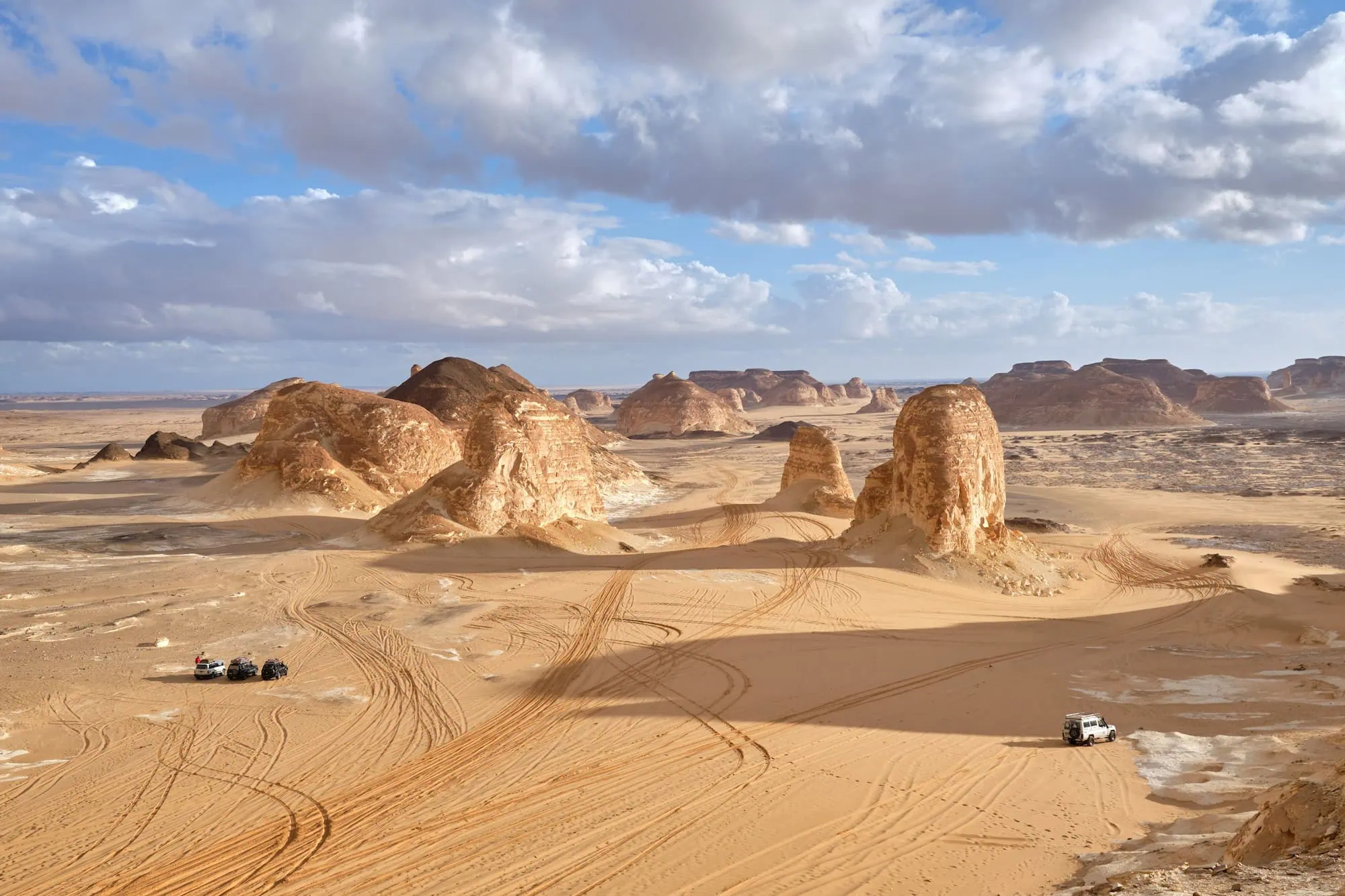 Desert vehicles with tire tracks in Egyptian White Desert landscape