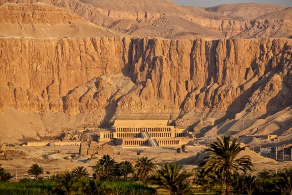 Sunset view of the Mortuary Temple of Hatshepsut against limestone cliffs at Deir el-Bahari, Luxor