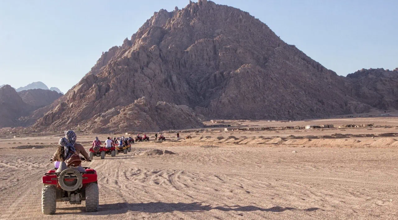 Beautiful South Sinai desert landscape. Line of off road quads, mountains at background. Extreme sports _ outdoors activities