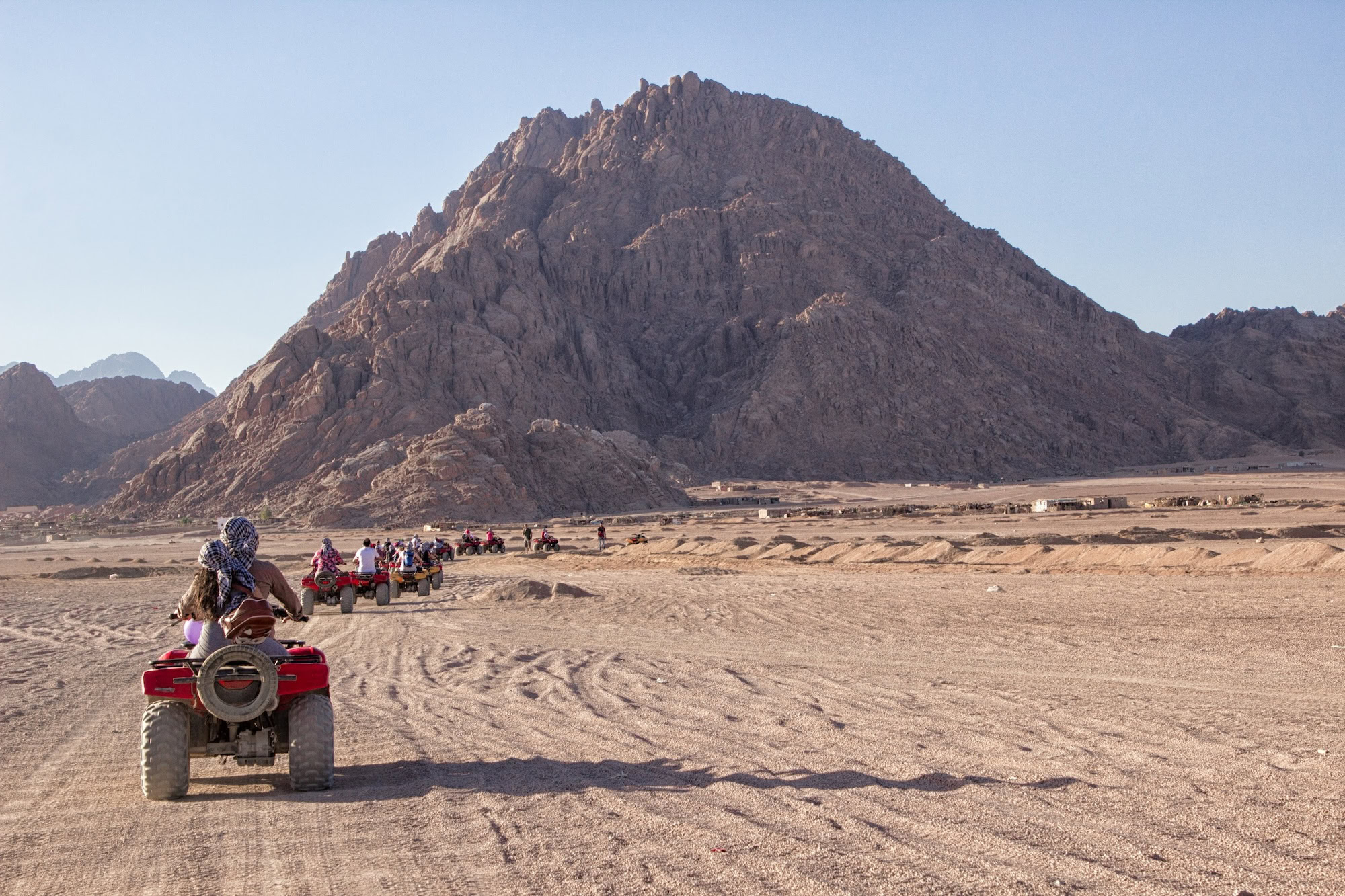 Beautiful South Sinai desert landscape. Line of off road quads, mountains at background. Extreme sports _ outdoors activities