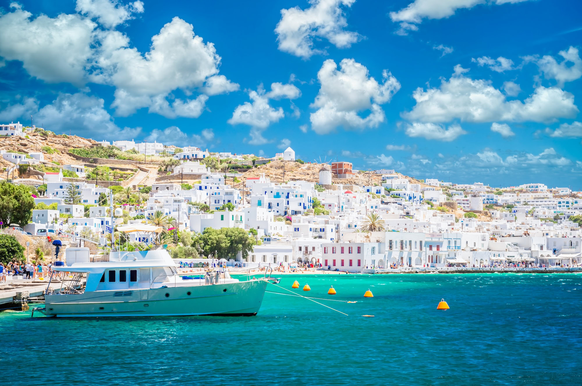 Vista do porto de Mykonos Town com iate, moinho de vento e edifícios brancos tradicionais