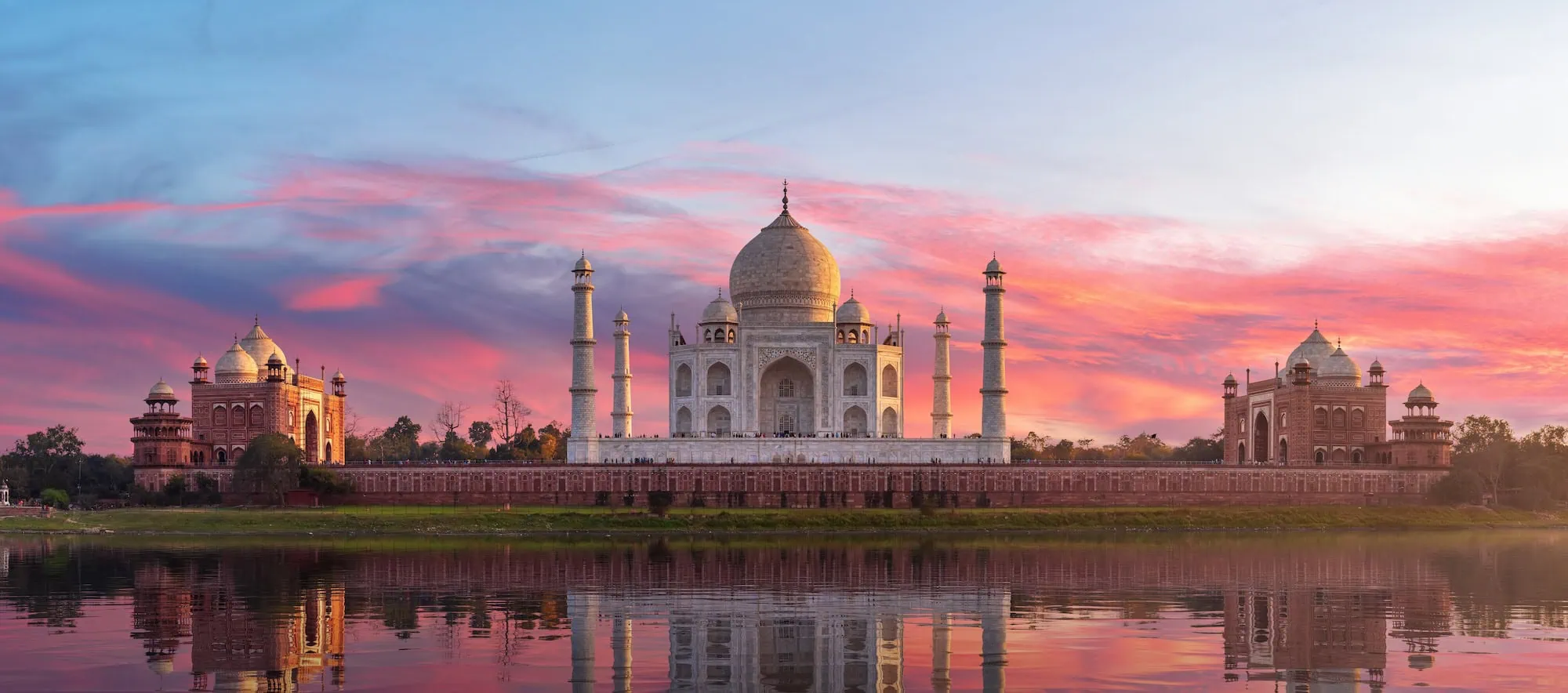 Vista romántica del Taj Mahal reflejado en el río con jardines