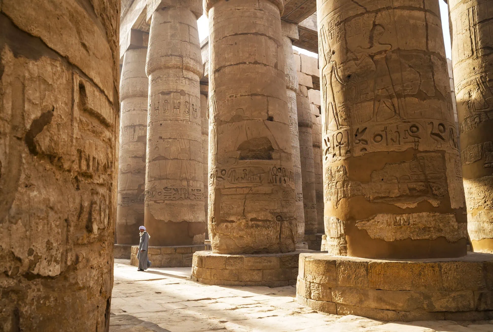 Visitors exploring the massive stone columns of the Great Hypostyle Hall at Karnak Temple