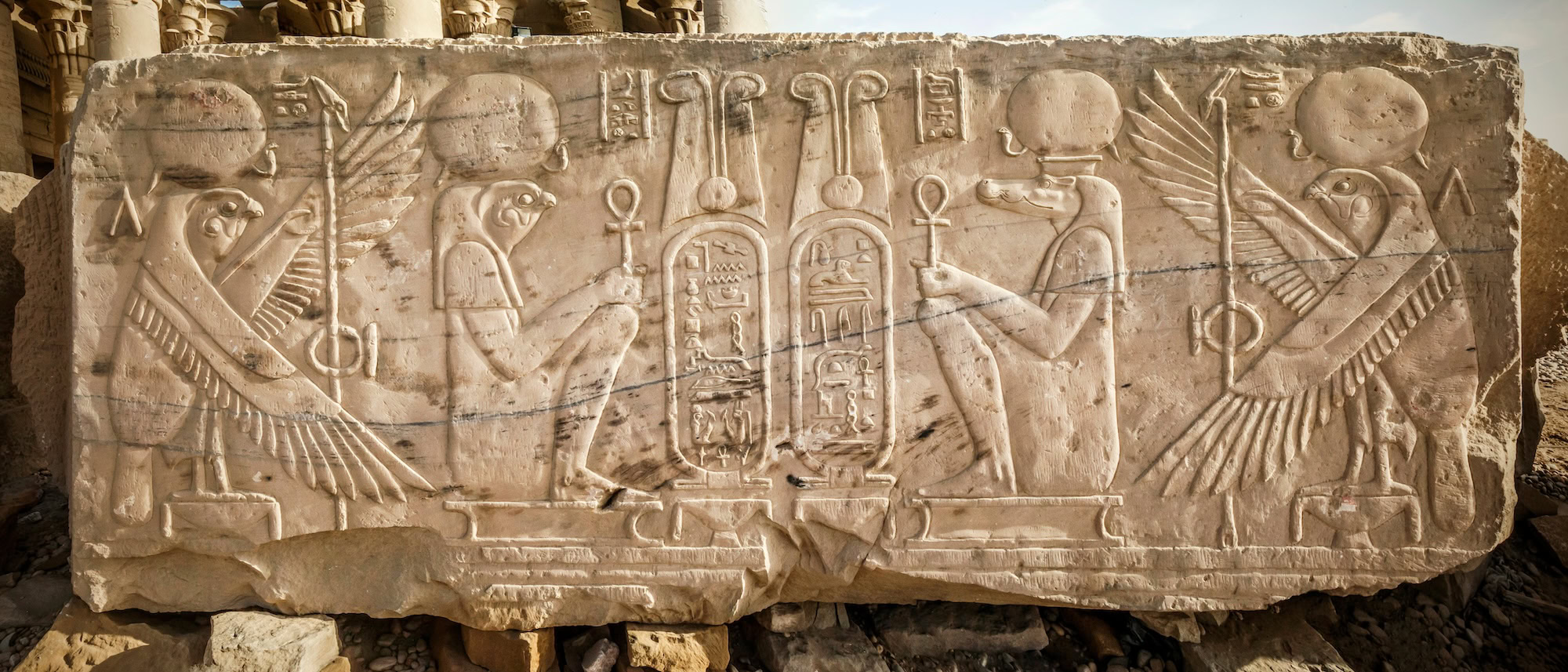 Ancient Egyptian hieroglyphs carved on stone temple wall