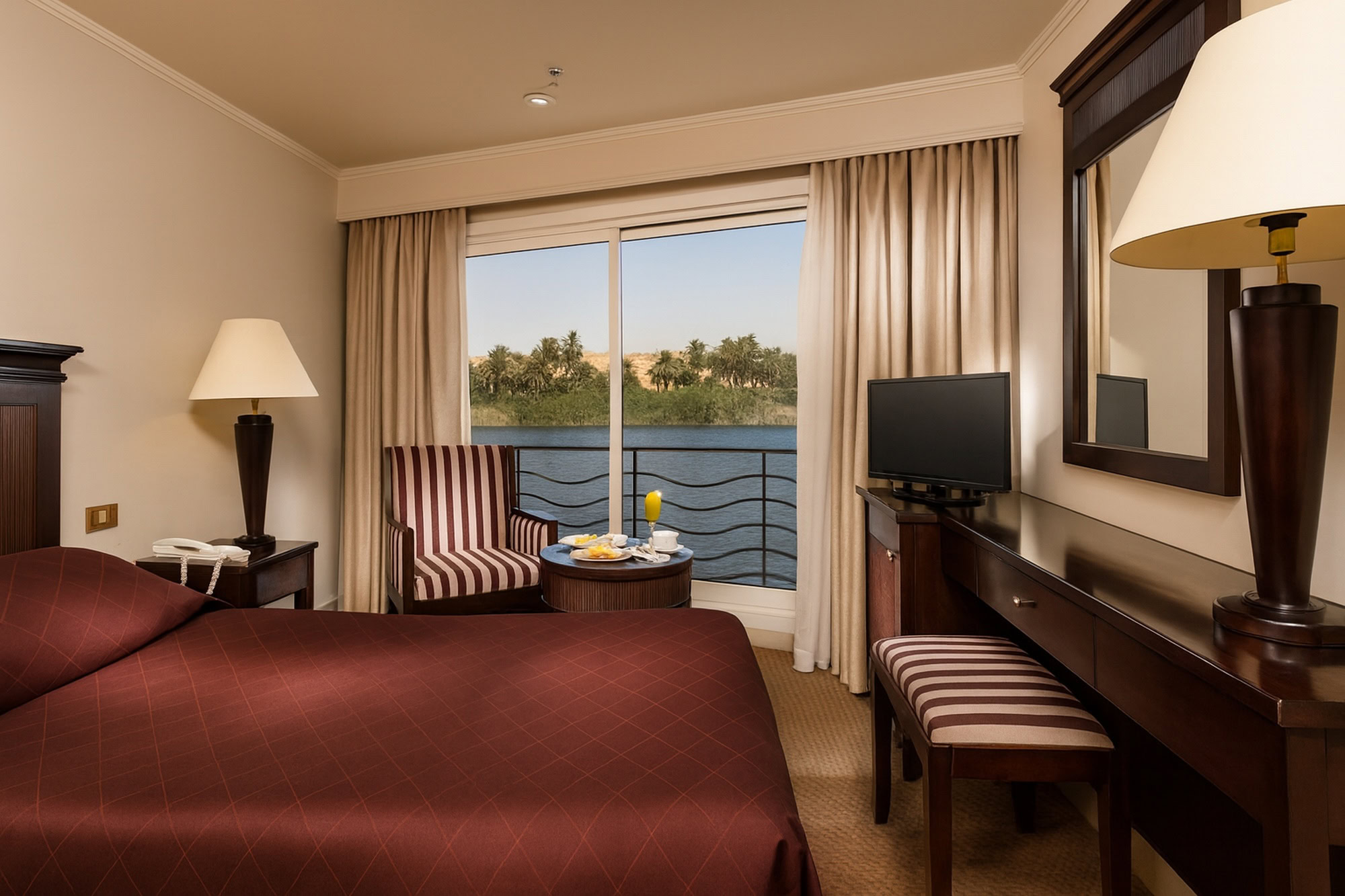 Cabina confortevole della Jaz Jubilee con letto matrimoniale e finestra panoramica sul Nilo